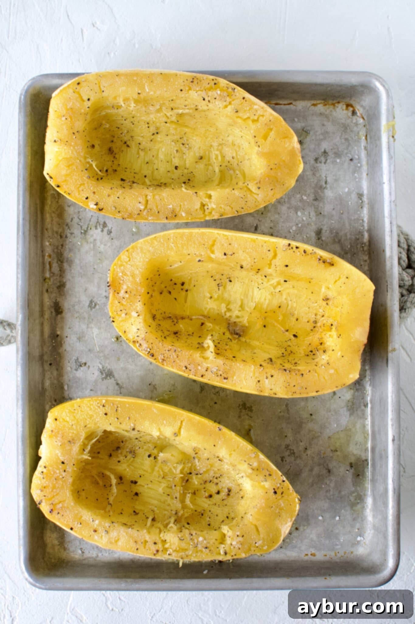 Close-up of roasted spaghetti squash, still warm from the oven, showcasing its tender texture.