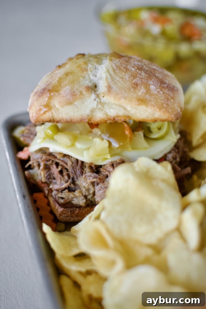 A close-up of the delicious Italian Beef Sandwiches Recipe presented on a platter with potato chips, ready to be enjoyed.