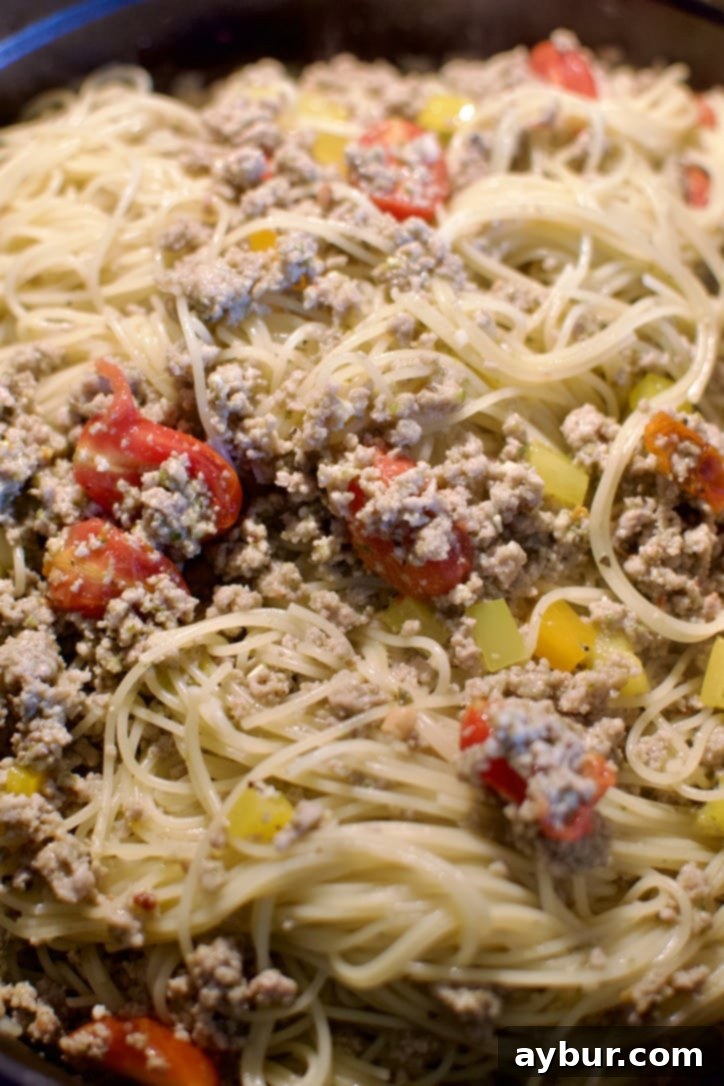 The finished Pesto Spaghetti, perfectly tossed and combined in a large pot, steam rising, ready to be served.