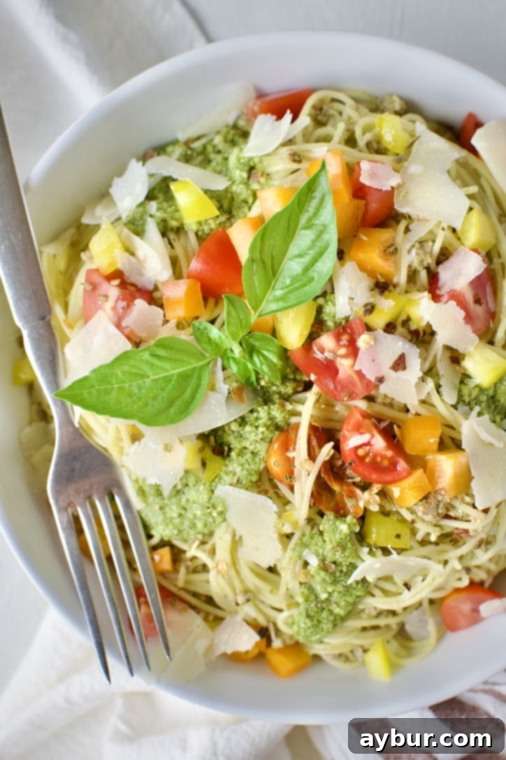 Another enticing shot of Pesto Spaghetti in a rustic bowl, garnished with basil leaves and parmesan, highlighting its fresh appeal.