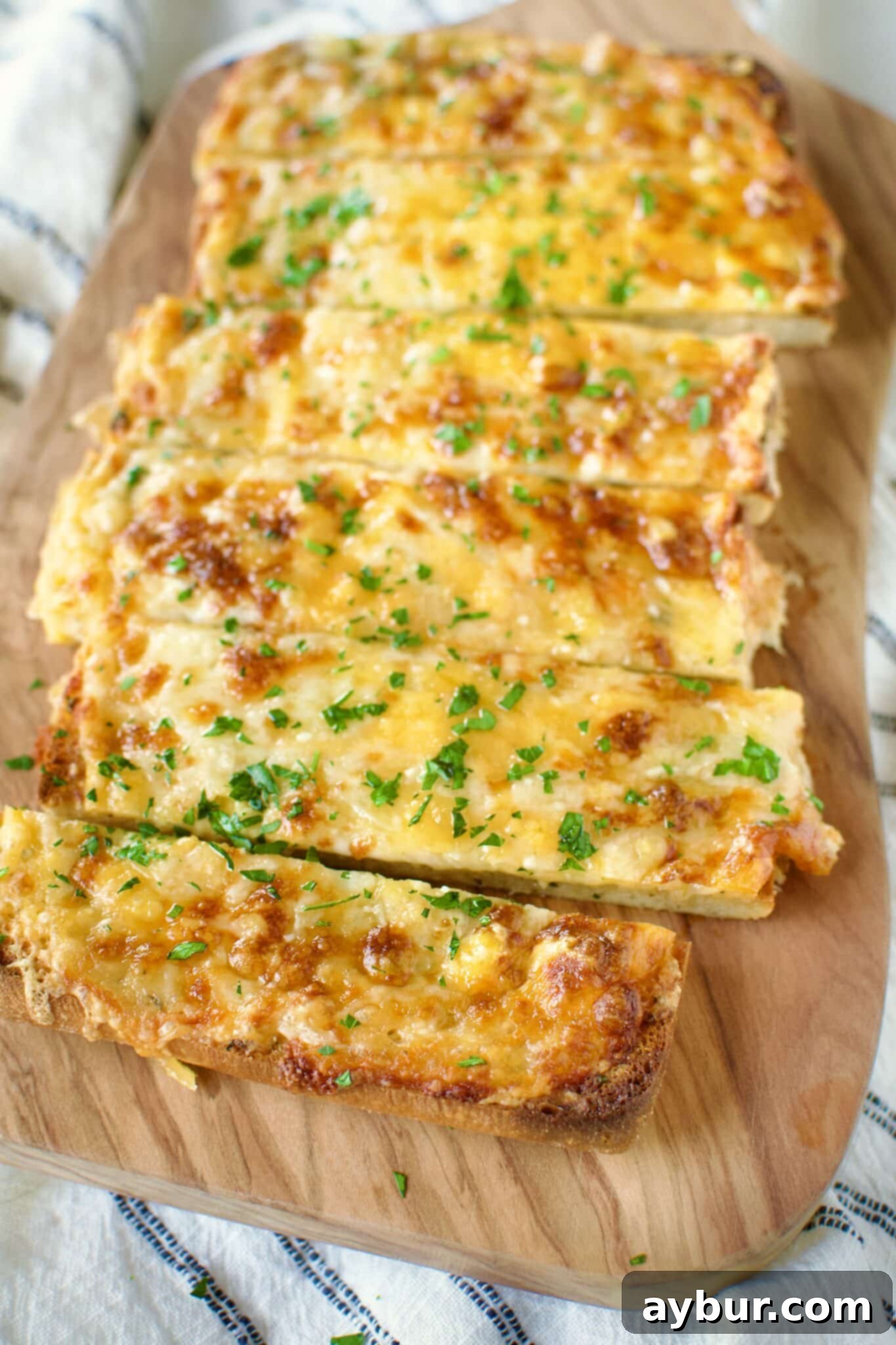 Perfectly sliced Cheesy Garlic Bread, golden brown and gooey, ready to be enjoyed as a delicious side dish.