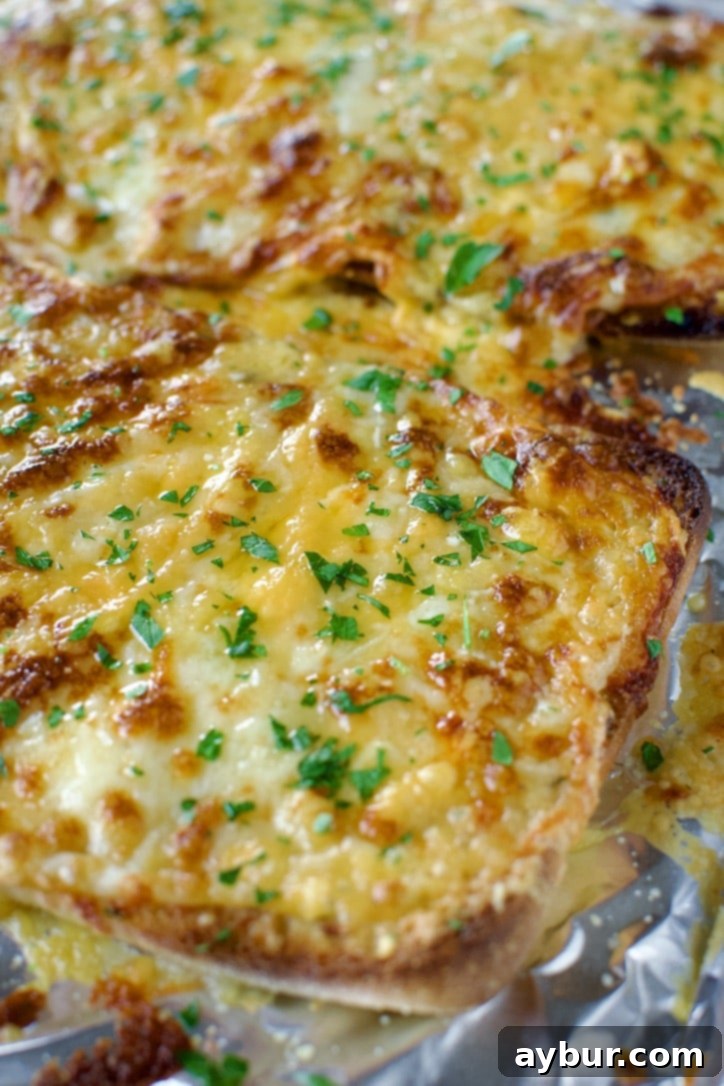 Close-up of the piping hot, gooey Cheesy Garlic Bread, showing off its crispy edges and perfectly melted cheese blend.