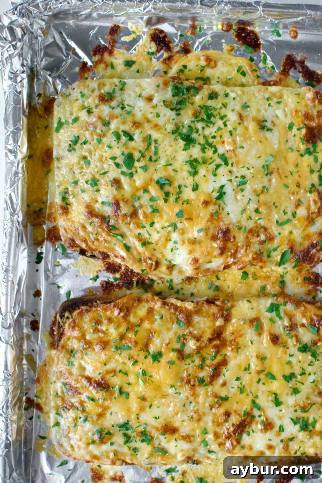 Cheesy Garlic Bread fresh out of the oven, with bubbly, golden cheese.