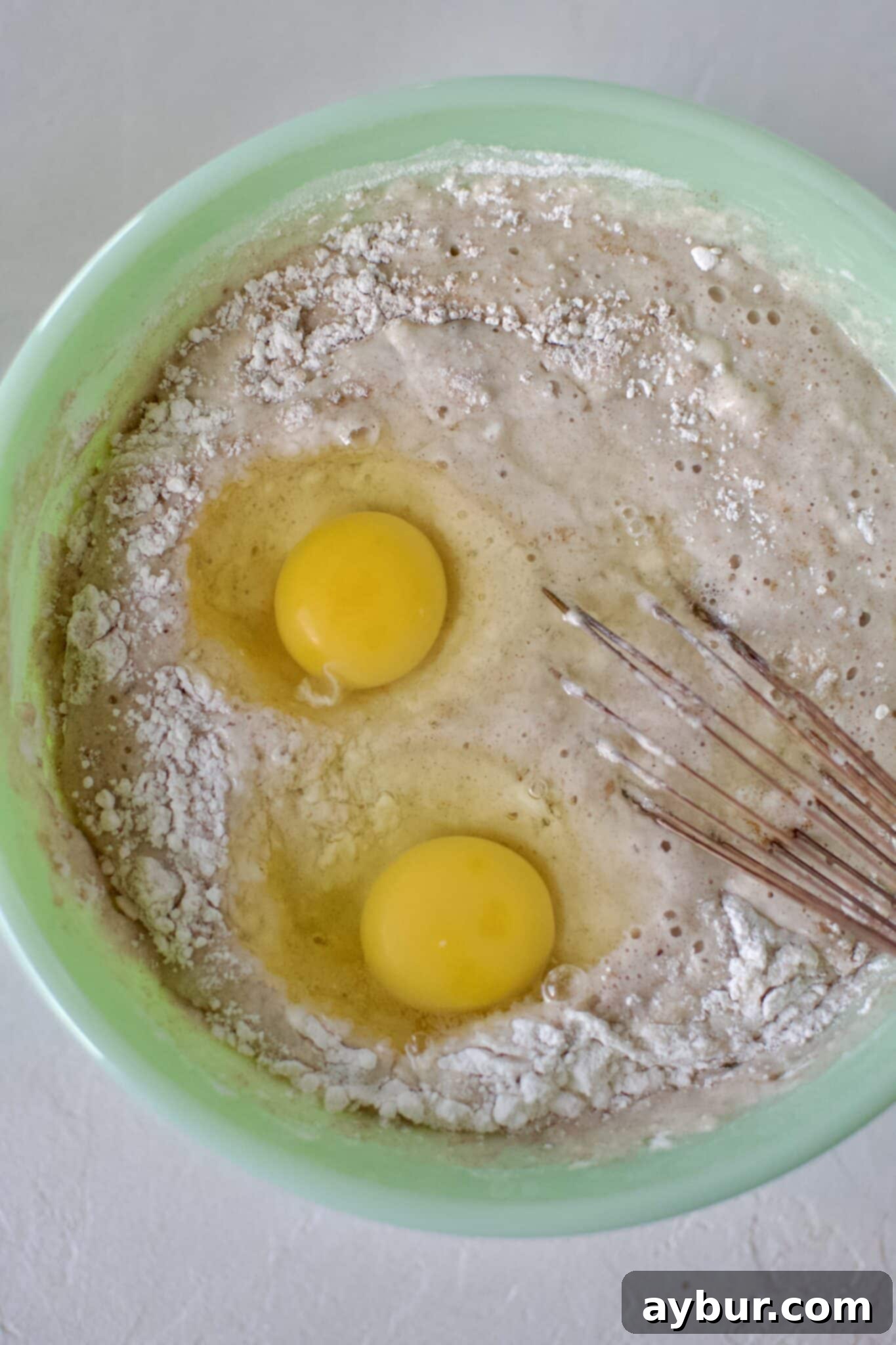 Golden Peach Pancakes 6 Lightly beaten eggs being incorporated into the peach pancake mix, ensuring richness and binding.