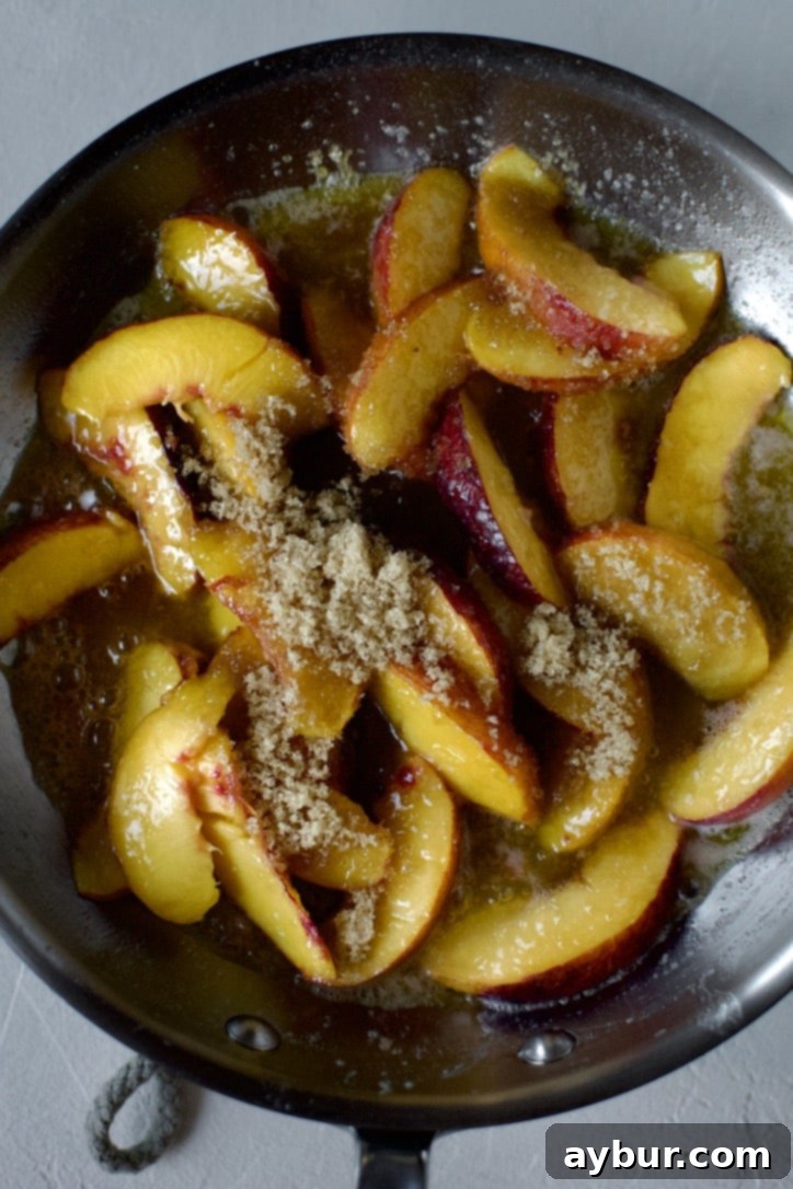Golden Peach Pancakes 9 Rich brown sugar being stirred into the sautéed peaches in the skillet, creating a luscious, caramelized coating.
