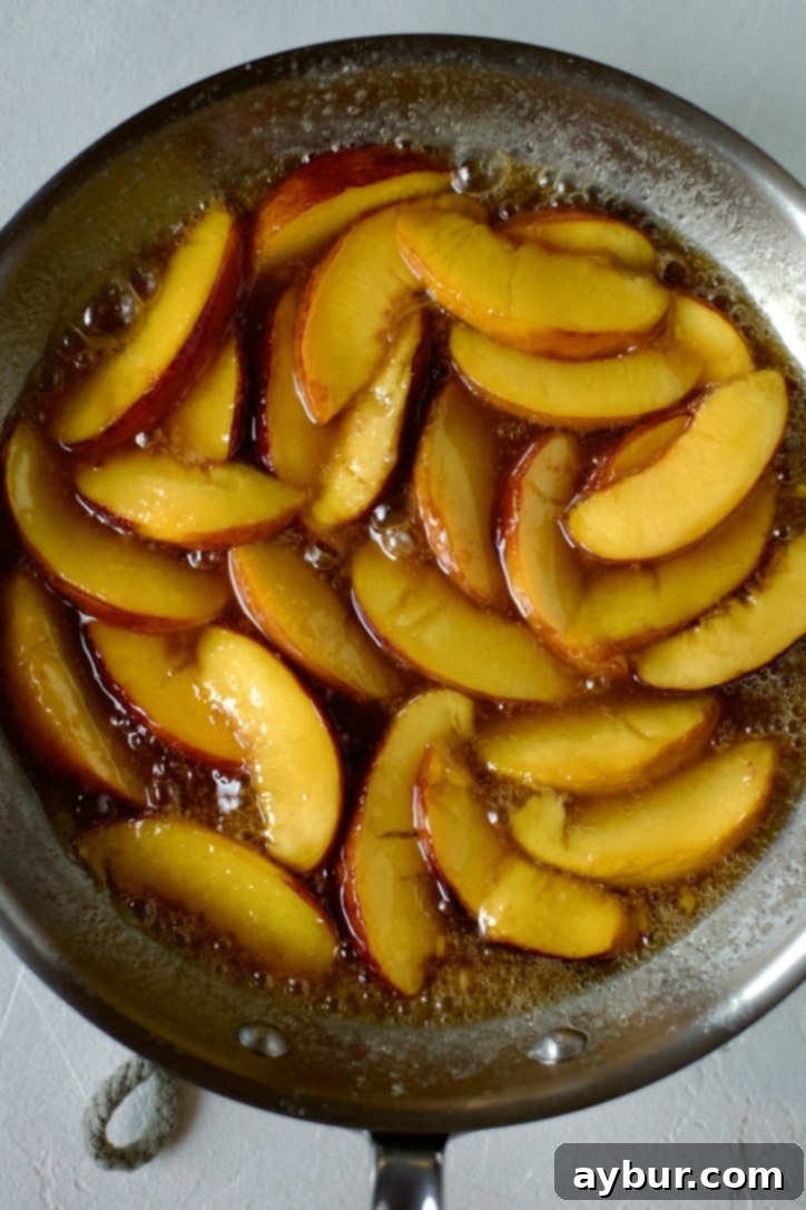 Golden Peach Pancakes 10 A fragrant mixture of maple syrup and whiskey being added to the caramelized peaches in the skillet, ready to be simmered into a delicious topping for pancakes.
