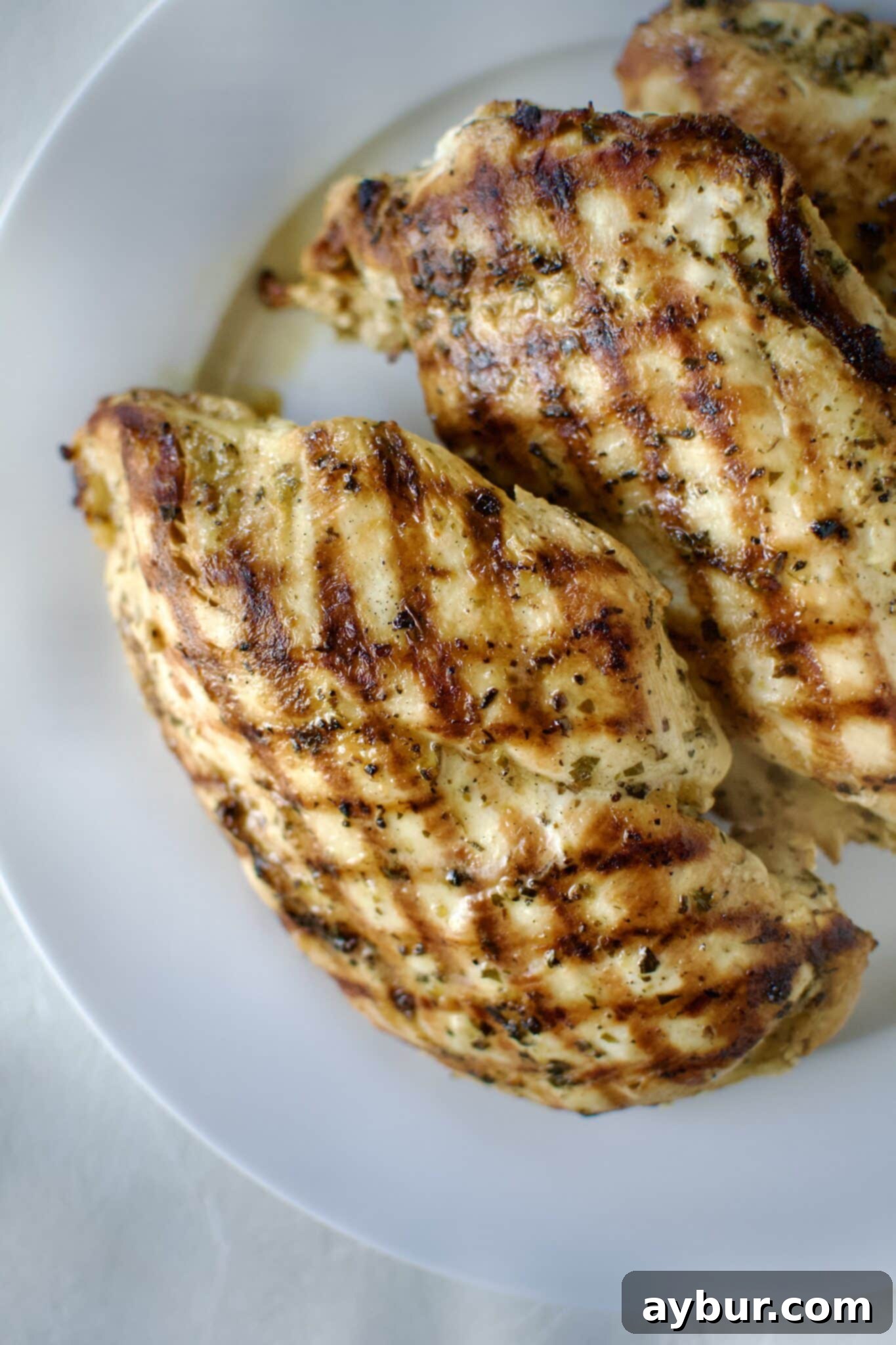 Italian Marinated chicken that has been grilled and is resting on a palate.