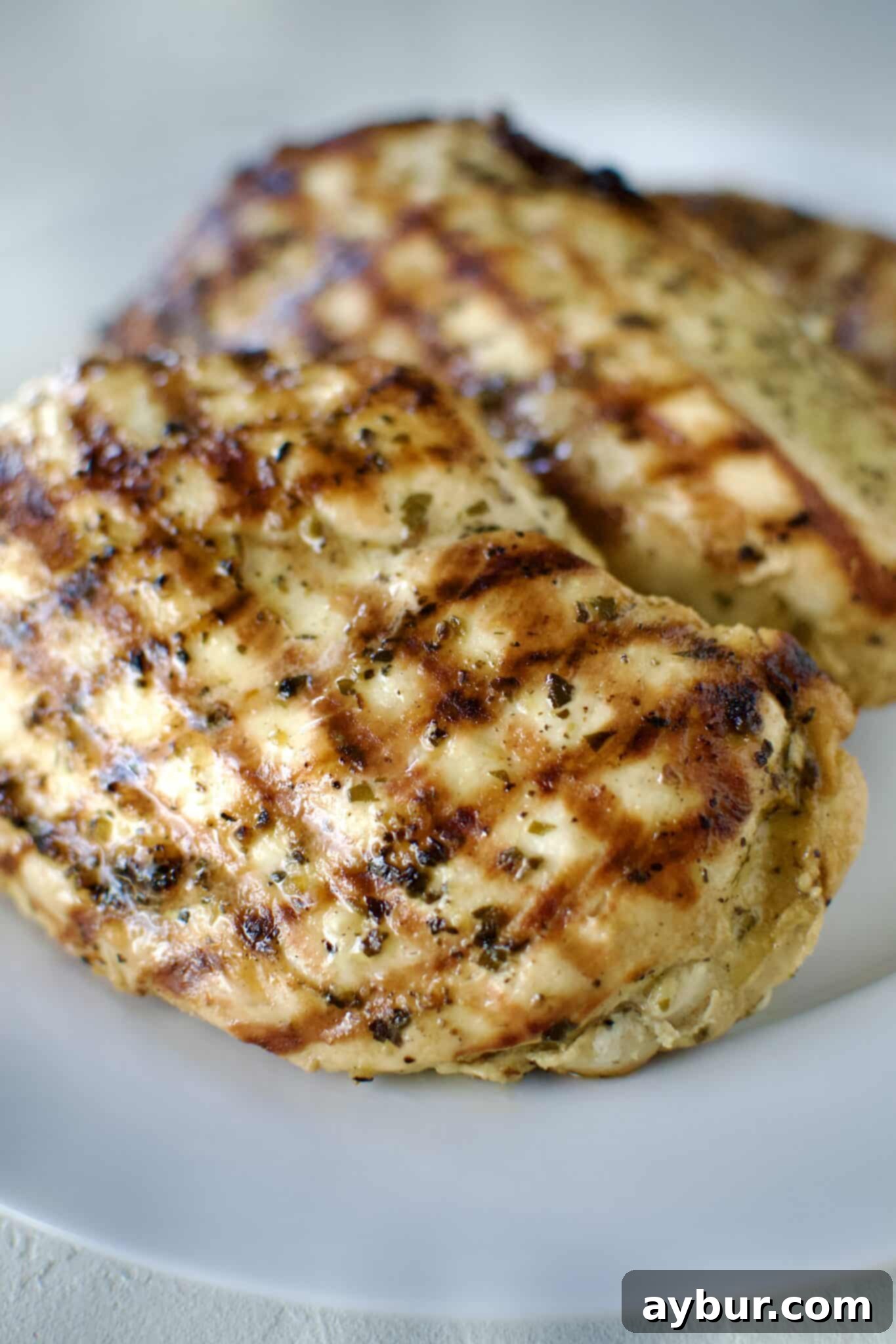 Italian Marinated chicken that has been grilled and is resting on a palate.