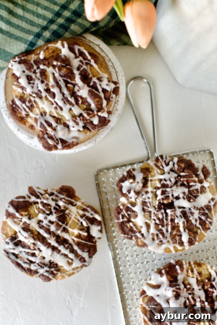 Golden Apple Crumb Muffins 11 Glazed Apple Streusel Muffins on a table displayed and ready to eat.