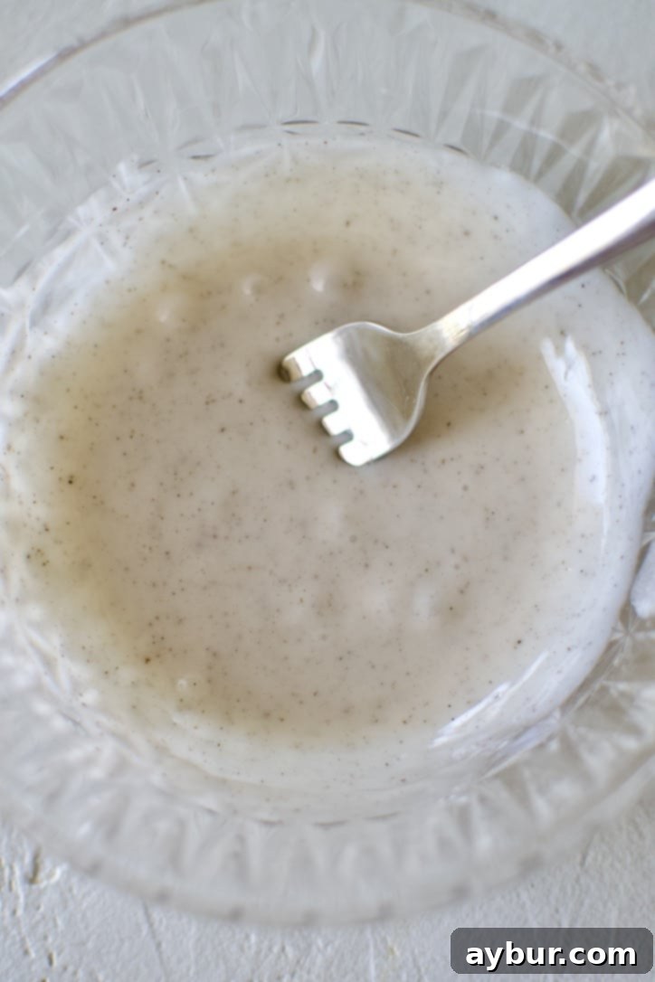 Golden Apple Crumb Muffins 9 Glaze that has been mixed up with a fork in a small bowl.