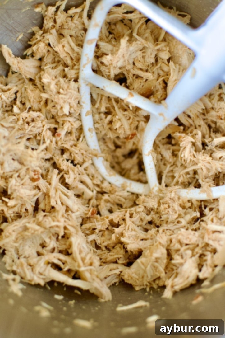 Shredding the tender Mexican chicken efficiently in a stand mixer.
