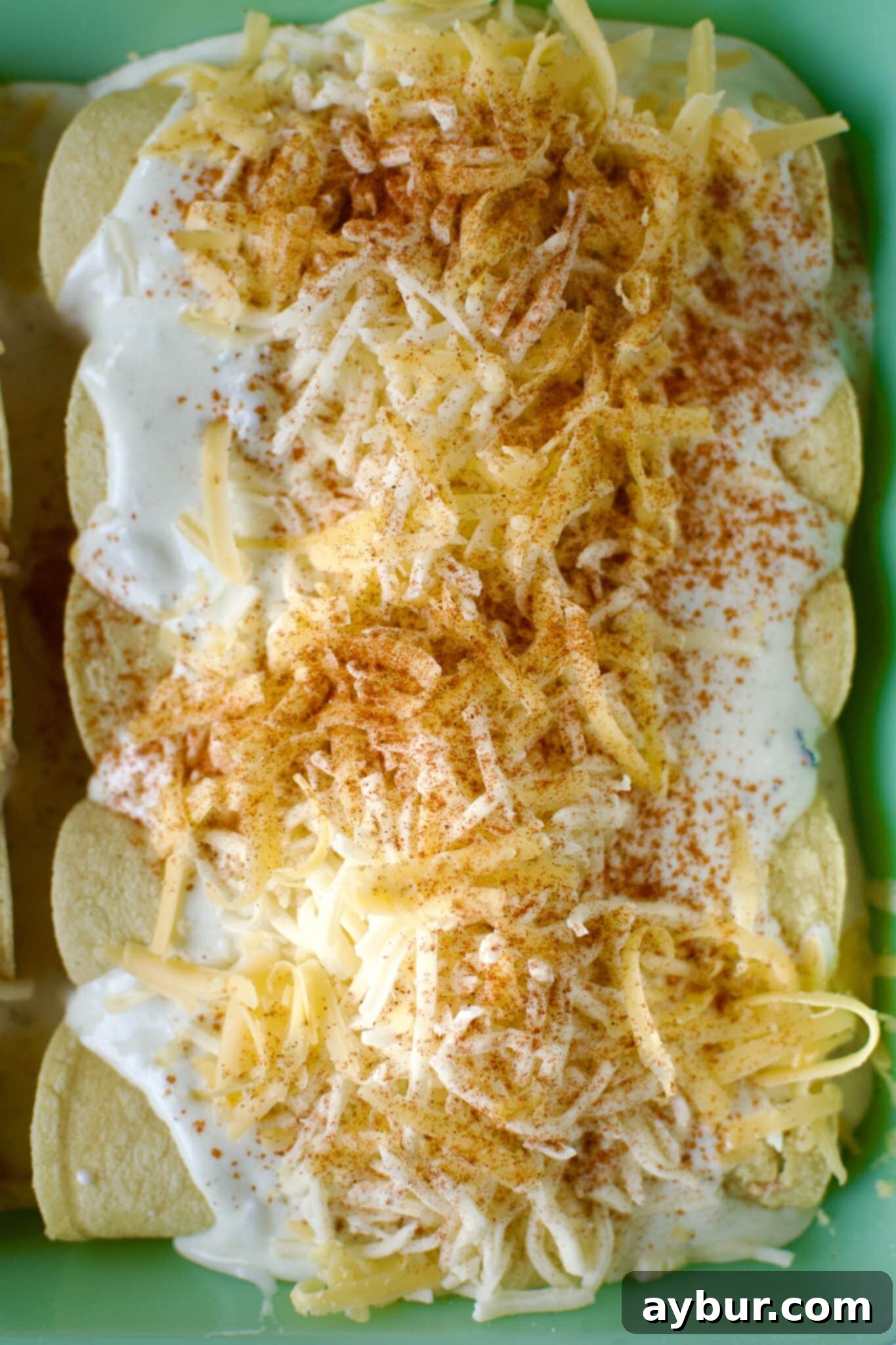Chicken filled tortillas rolled up and placed in a baking dish that has been lined with sour cream enchilada sauce. Then topped with more sauce and cheese before baking.