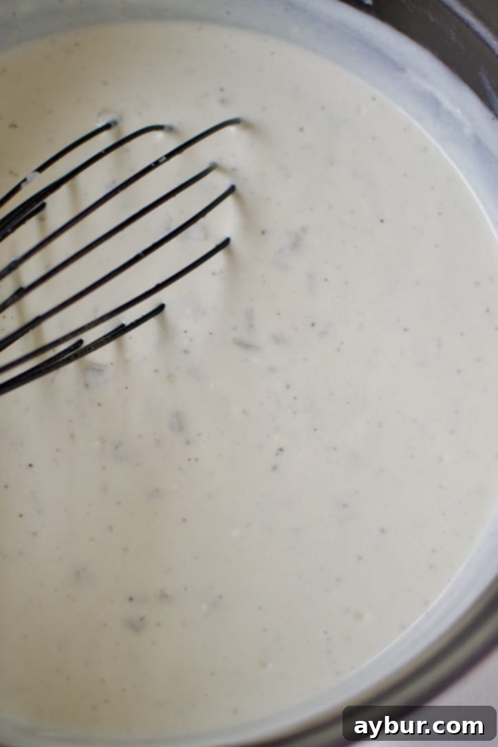 Velvety Sour Cream Enchilada Sauce 7 The finished Sour Cream Enchilada Sauce, creamy and ready, being whisked in the pot.