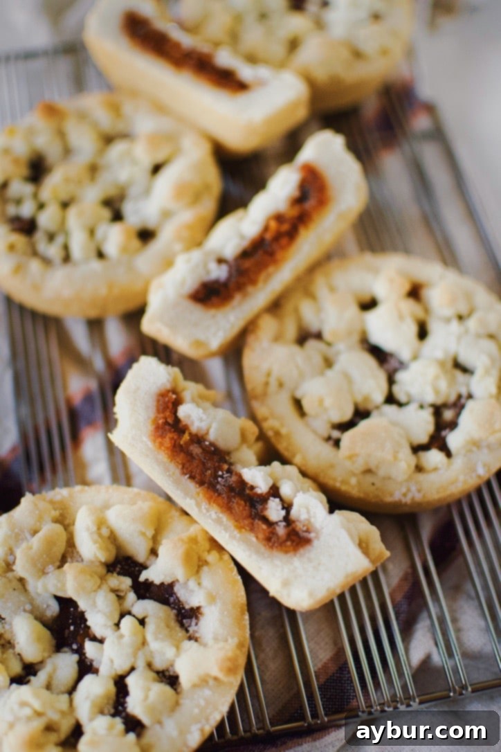 Spiced Pumpkin Delights 2 Freshly baked pumpkin tartlets on a cooling rack, showcasing their golden crusts and a hint of the pumpkin jam filling.