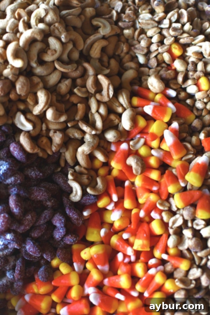 Close-up of candy corn and nuts being poured into a large mixing bowl.