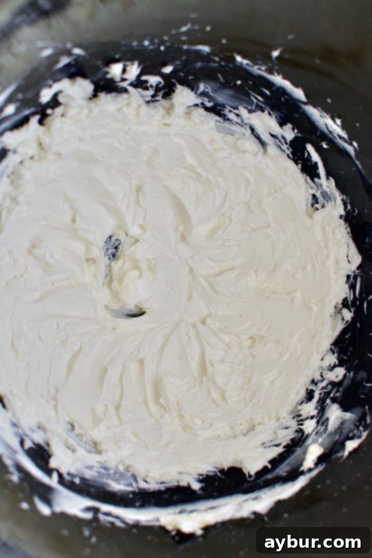 Cream Cheese whipped in the bowl of a stand mixer.