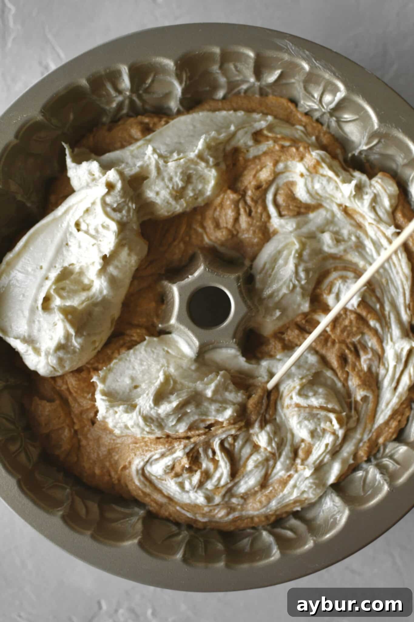 Pumpkin Spice Swirl Pound Cake 11 Swirling the first layer of plain and pumpkin cake together in the pan.