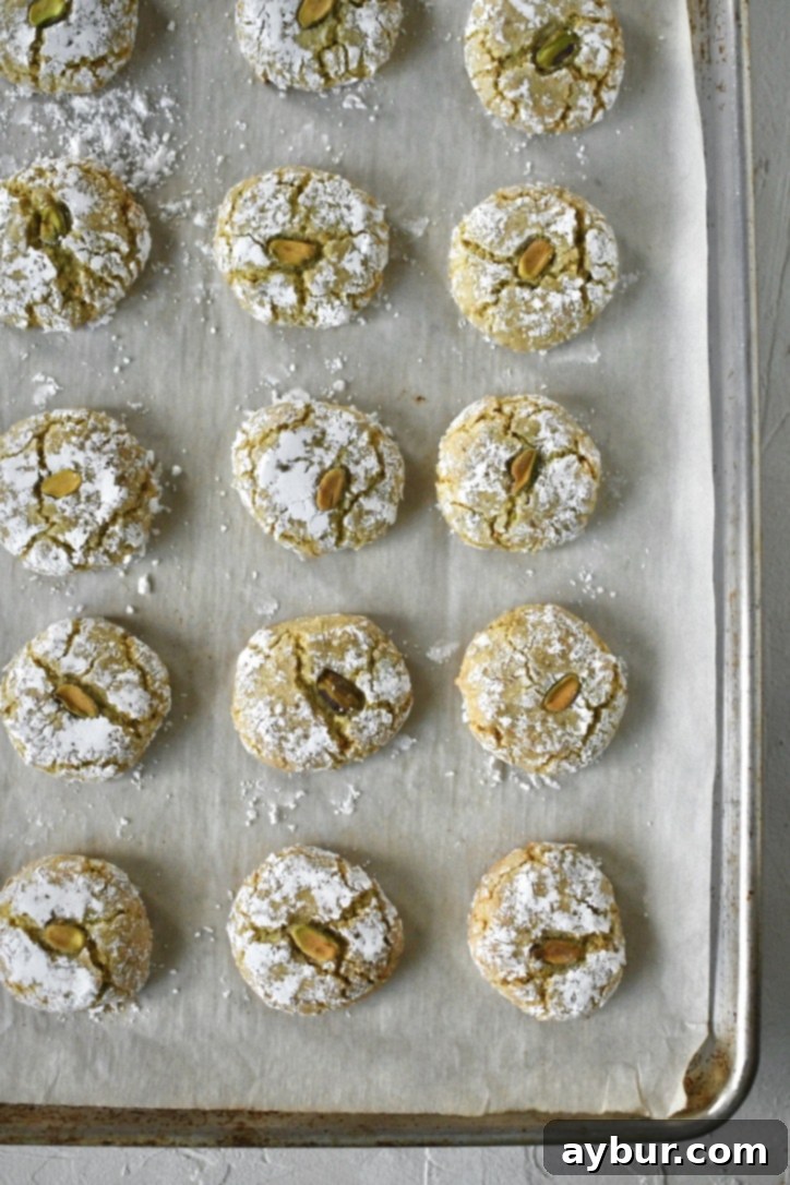 Pistachio Amaretti Cookies fresh out of the oven, showing their characteristic crackled tops and light golden edges.