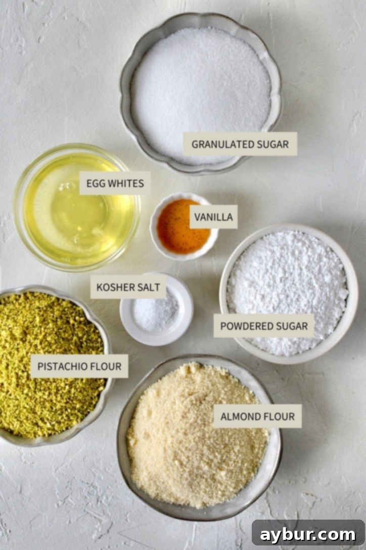 A beautiful flat lay of all the essential ingredients needed to bake Pistachio Amaretti Cookies, including raw pistachios, almond flour, sugar, and egg whites.