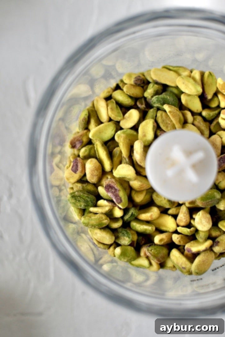 Raw pistachio nuts placed in a food processor, ready for blending into flour.