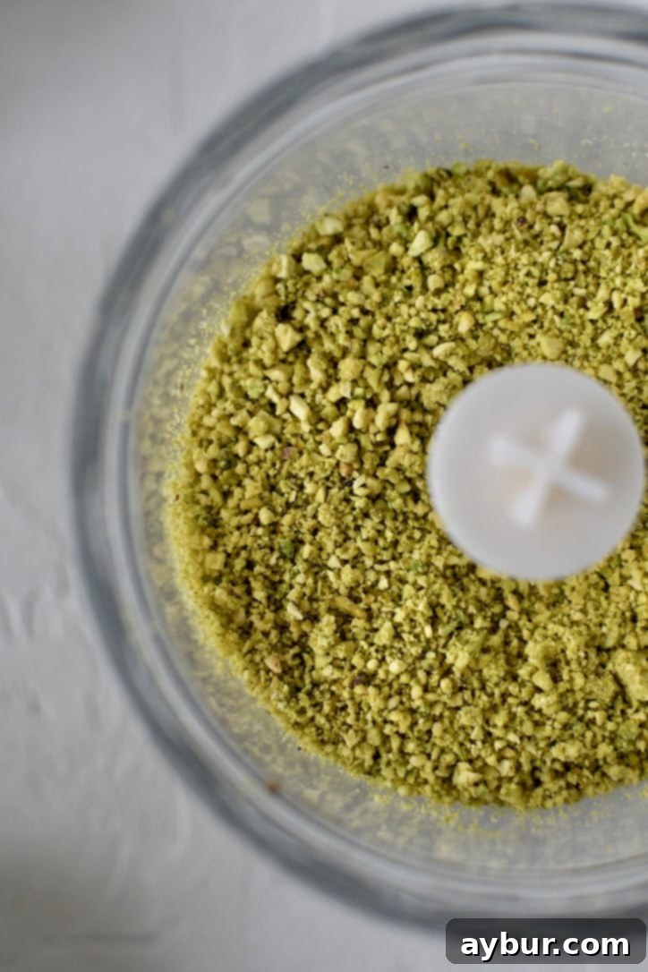 Finely ground pistachio flour in a food processor after careful blending, showing its powdery texture.