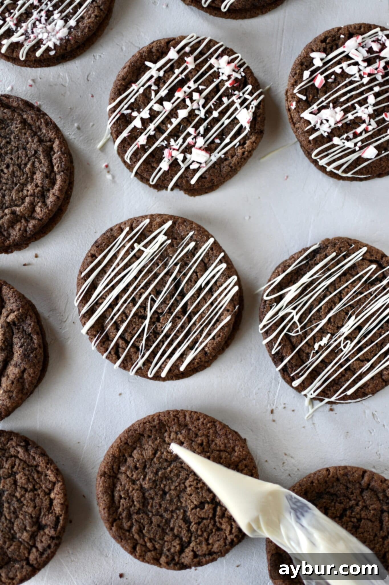 Peppermint Chocolate Delights 12 White chocolate being drizzled artistically over the assembled chocolate peppermint cookies.