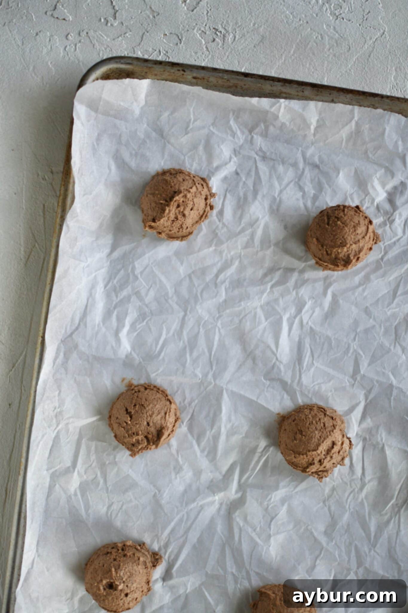 Peppermint Chocolate Delights 7 Portioned cookie dough scoops neatly arranged on a parchment-lined baking tray, ready for chilling.