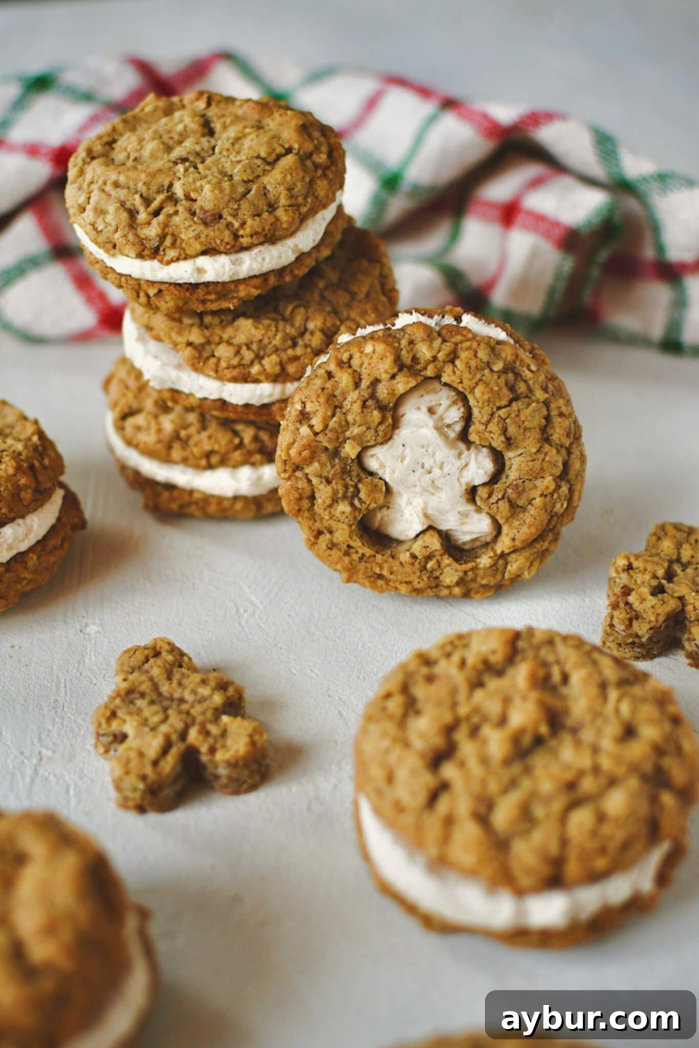 Festive Gingerbread Oatmeal Cream Pies 2 A freshly baked Gingerbread Oatmeal Cream Pie, with a charming gingerbread man shape cut out of the top cookie, revealing the creamy white filling. Two cookies are perfectly sandwiched together, resting on a rustic wooden surface, evoking a cozy holiday feel.