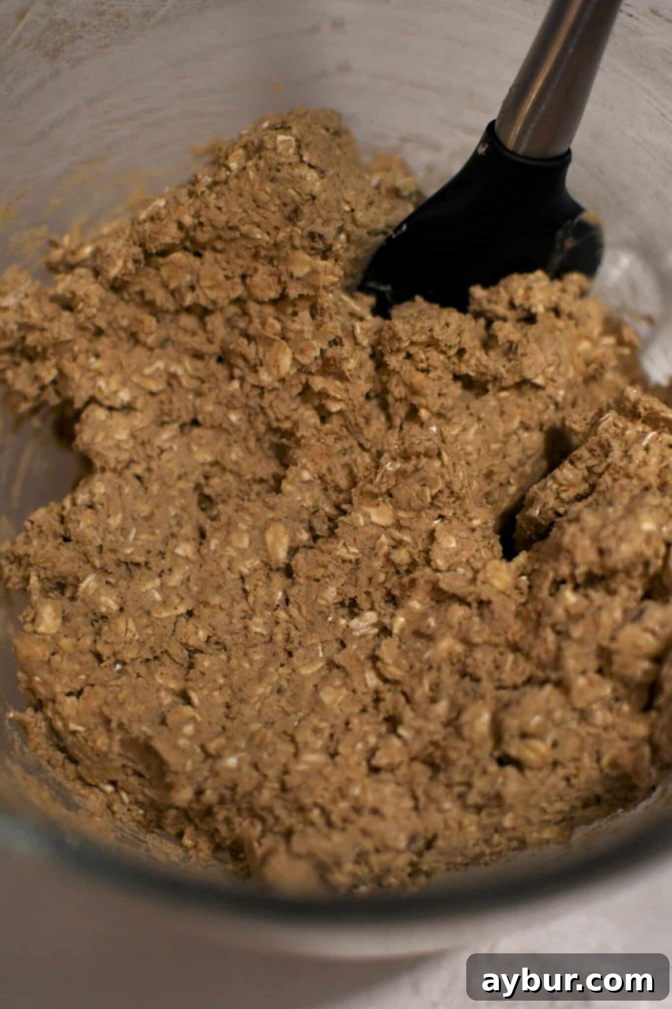 Festive Gingerbread Oatmeal Cream Pies 6 Close-up of fully mixed gingerbread oatmeal cookie dough, showcasing its rich texture and flecks of oats and pecans.