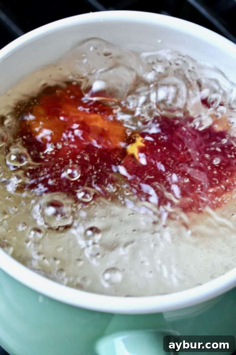 Delicious Homemade Peach Jam 5 Whole peaches blanching in boiling water.