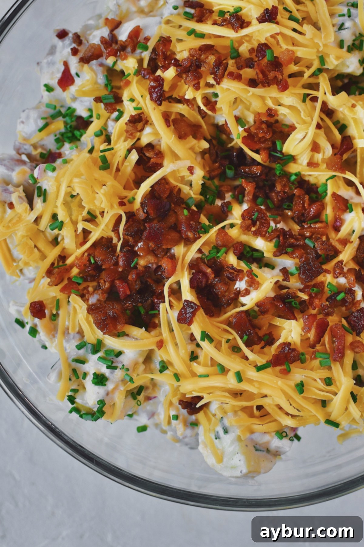 Creamy Ranch Potato Salad 2 Ranch Potato Salad in a glass bowl topped with chives, bacon, and cheddar. Ready to serve.