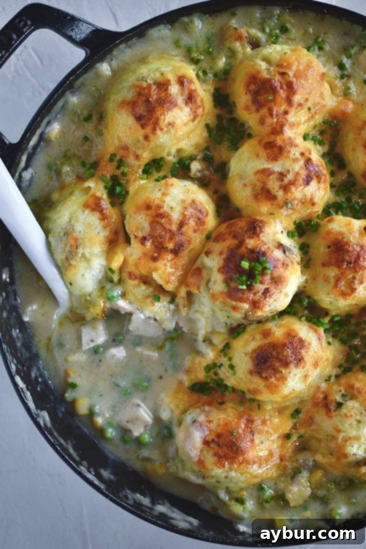 Golden Chicken Mash Bake 16 Finished Chicken Shepherd's Pie just out of the oven, serving a portion out of the pan with a big spoon.