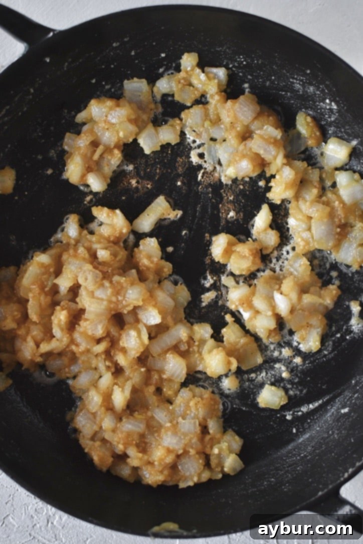 Golden Chicken Mash Bake 5 Cooked onions in roux before adding the stock to make the sauce, appearing translucent and slightly browned.