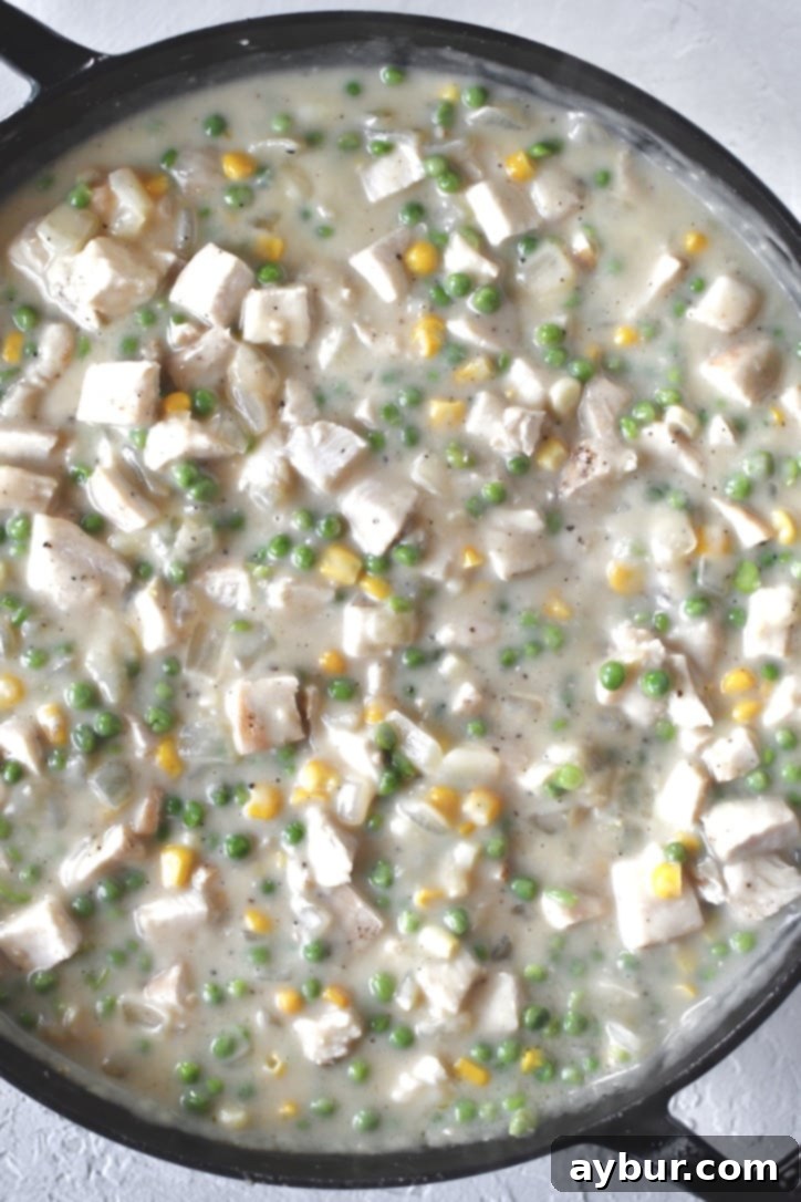 Golden Chicken Mash Bake 9 The Chicken Shepherd's Pie sauce simmering and fully formed with chicken and vegetables.