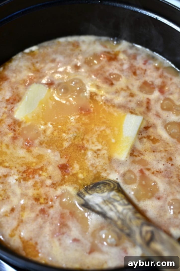 Placing the parmesan rind in the pot before simmering it for a bit.