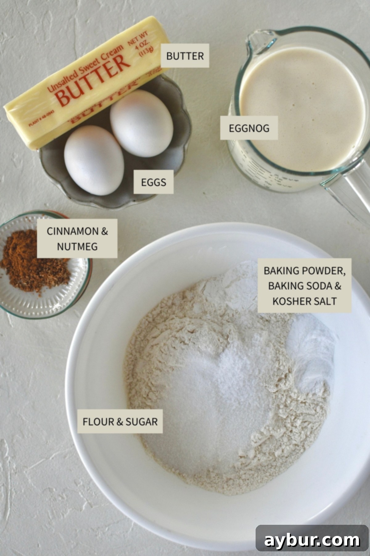 Festive Eggnog Pancakes 3 Ingredients needed to make delicious Eggnog Pancakes, including flour, eggs, eggnog, and spices.
