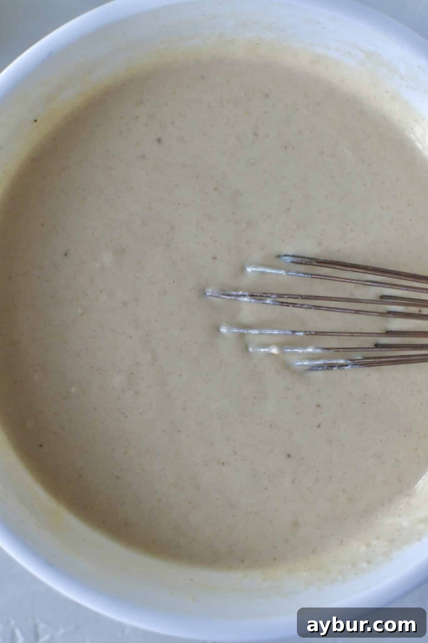 Festive Eggnog Pancakes 5 Adding liquid ingredients to the dry mix to form Eggnog Pancake batter.