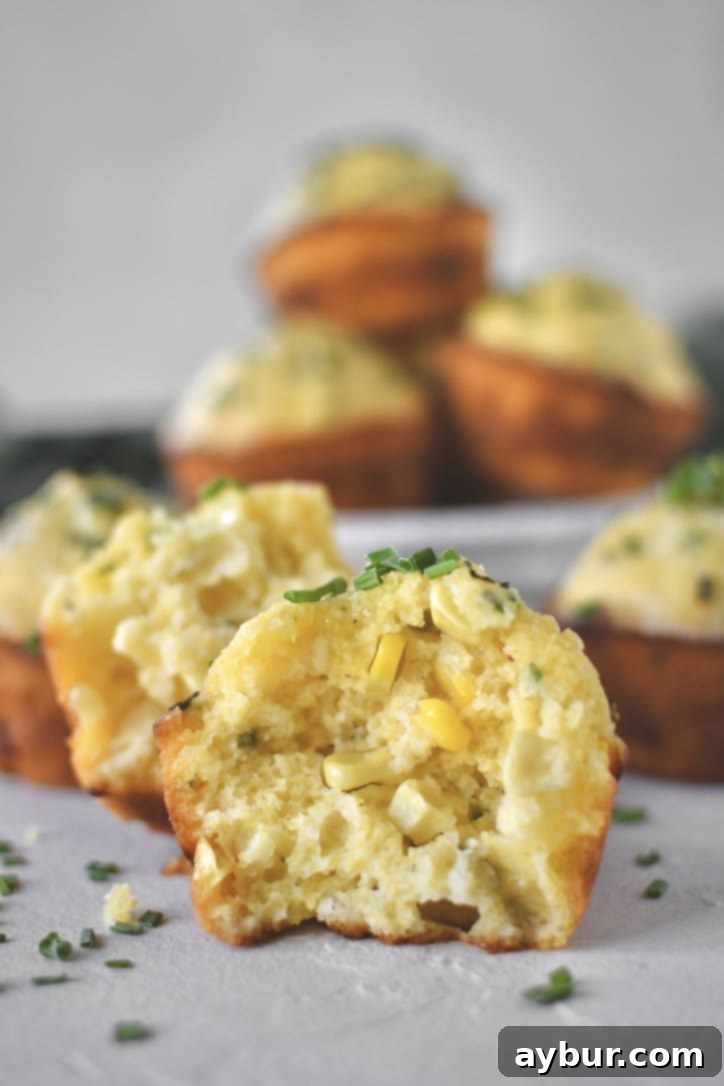 Cornbread Muffins scattered on counter, one split in half.