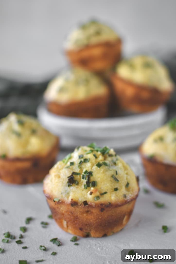 Cornbread Muffins stacked on a plate ready to be eaten.