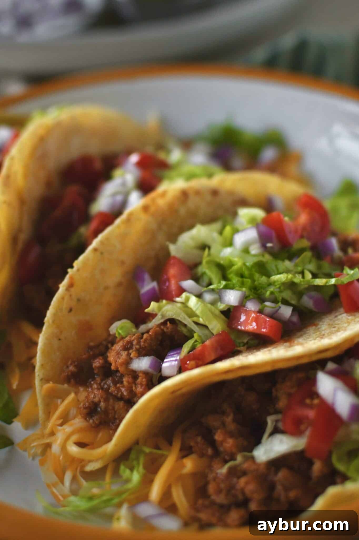 A plate of perfectly assembled Ground Turkey Tacos, ready for a delicious meal, featuring a variety of fresh toppings.