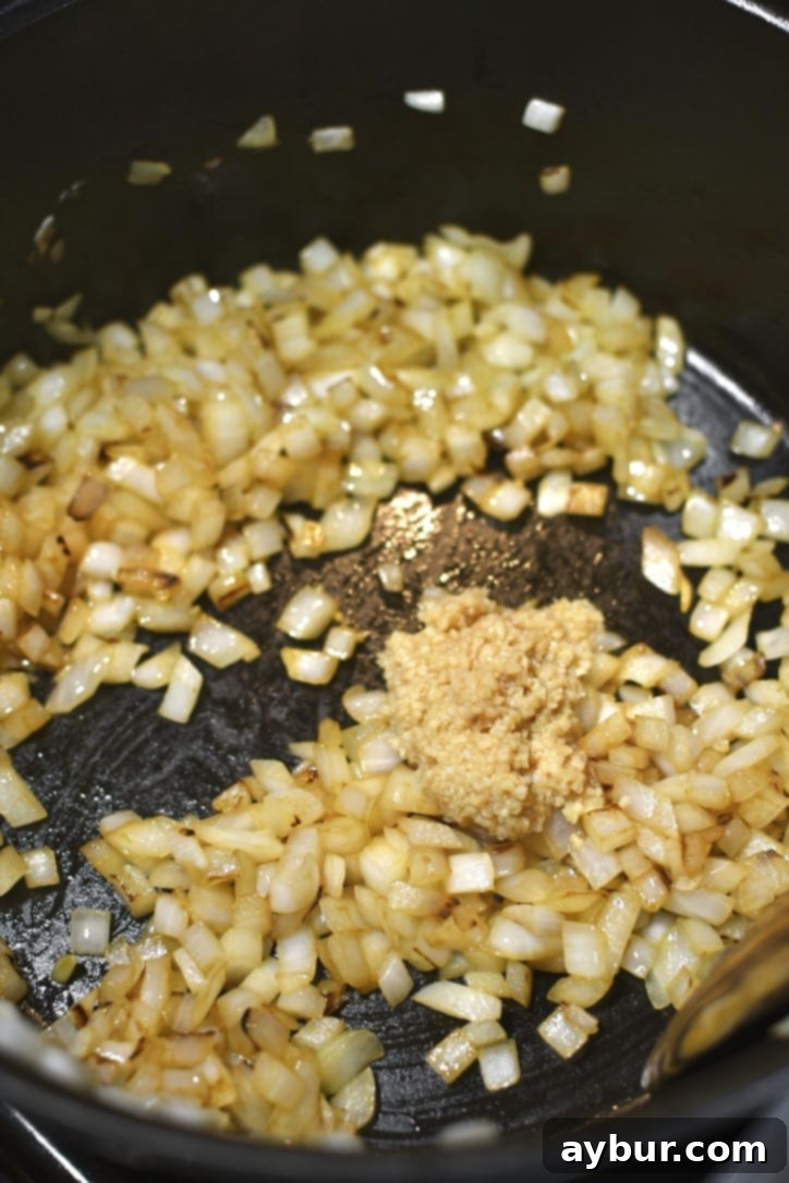 Diced onions being sautéed in olive oil until soft and golden, ready for garlic and turkey.
