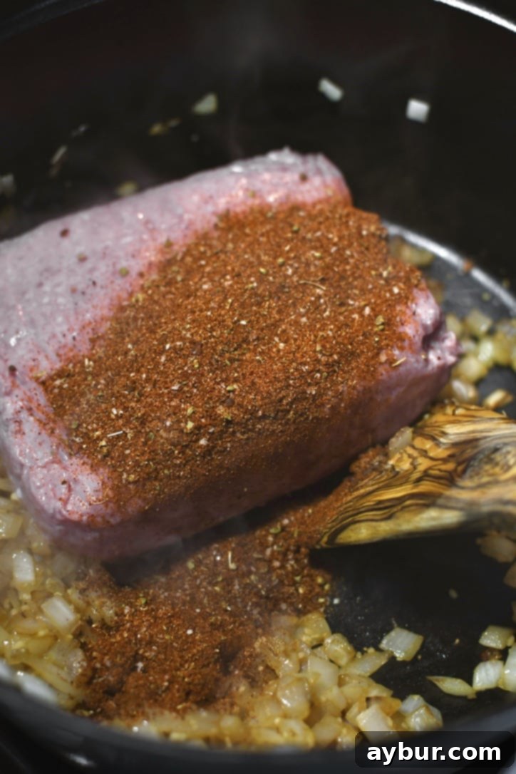 Adding lean ground turkey and aromatic homemade taco seasoning to the sautéed onions and garlic in a large pot.