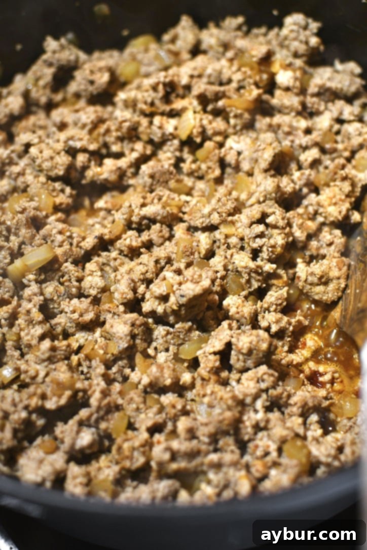 Perfectly browned ground turkey taco meat simmering in a large pot, coated with rich sauce.