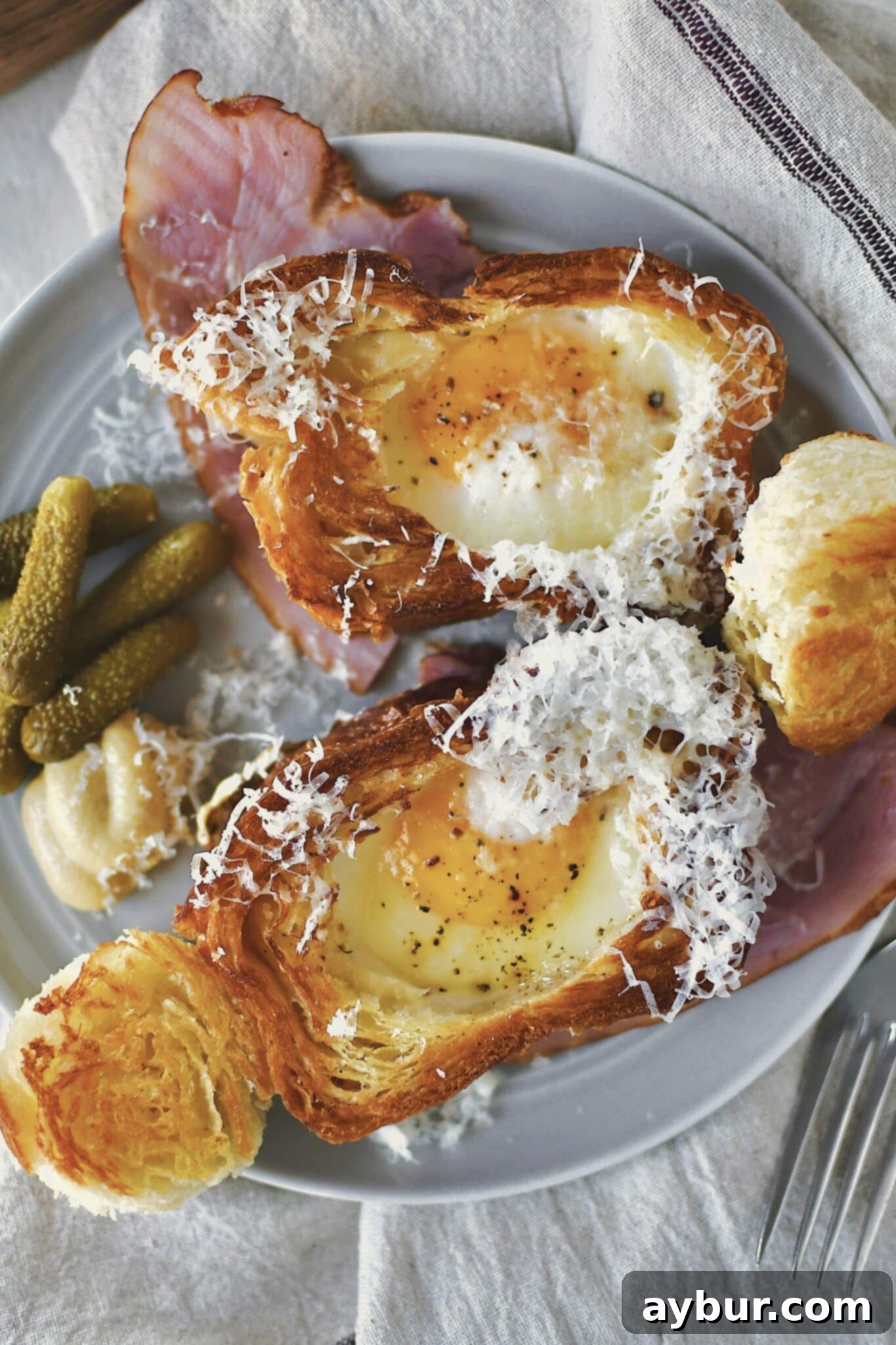 Eggs in a Basket served over a ham steak and topped with gruyere cheese.