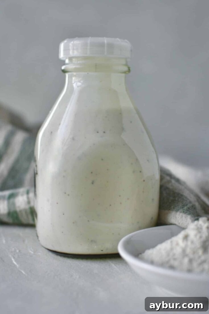 Creamy ranch dressing in a glass jar, perfectly chilled and ready for serving, on a rustic wooden background.