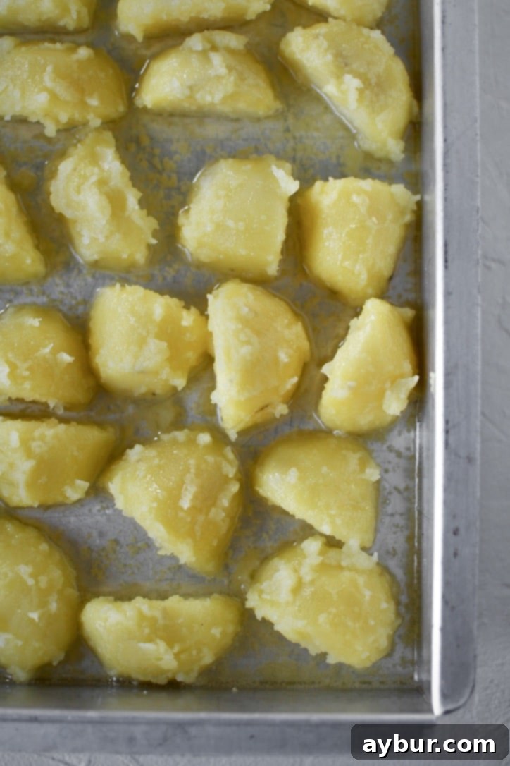 Addictively Crispy Roasted Potatoes 7 Carefully placing the "fuzzed" potatoes into a preheated baking pan with hot oil, ensuring even distribution.