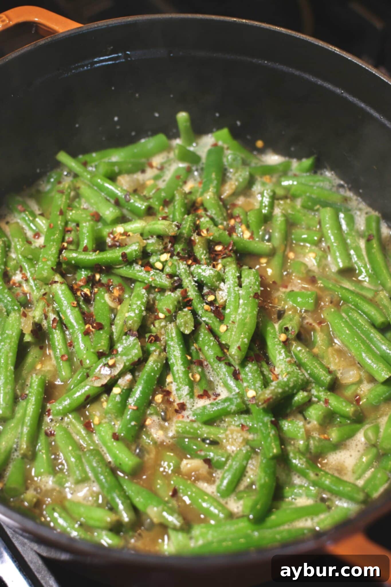 Chicken stock, vinegar, salt and pepper flakes added to the pot, beans before simmering.