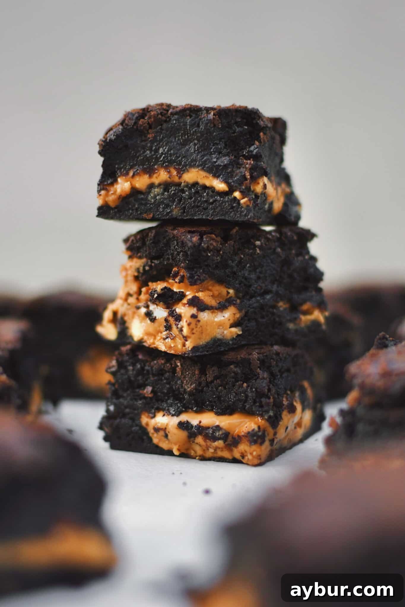 Peanut Butter Brownies stacked and scattered on a platter, cut and ready to eat.