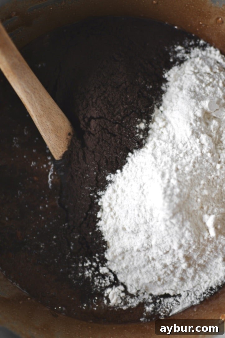 Adding in the cocoa powder and flour to the brownie batter.
