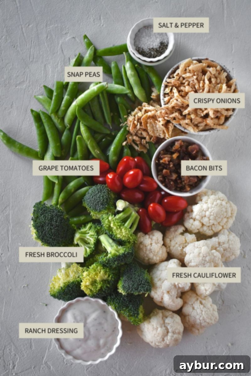 Crisp Snap Pea Salad 3 Assortment of fresh ingredients for Snap Pea Salad, including snap peas, broccoli, cauliflower, grape tomatoes, bacon bits, and crispy onions.